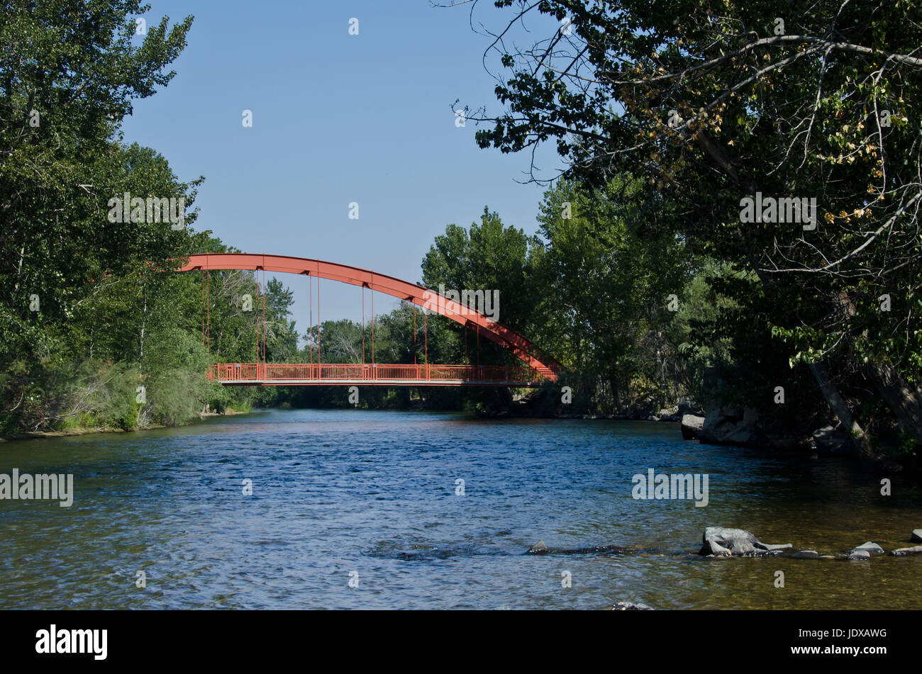 Red Bridge Extending Over the River Stock Photo