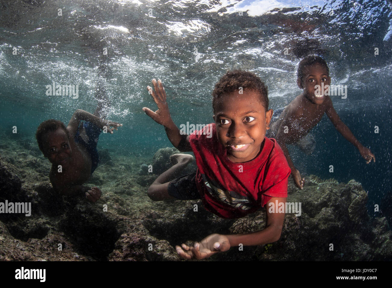 Kids splashing in Ocean, Melanesia, Pacific Ocean, Solomon Islands Stock Photo