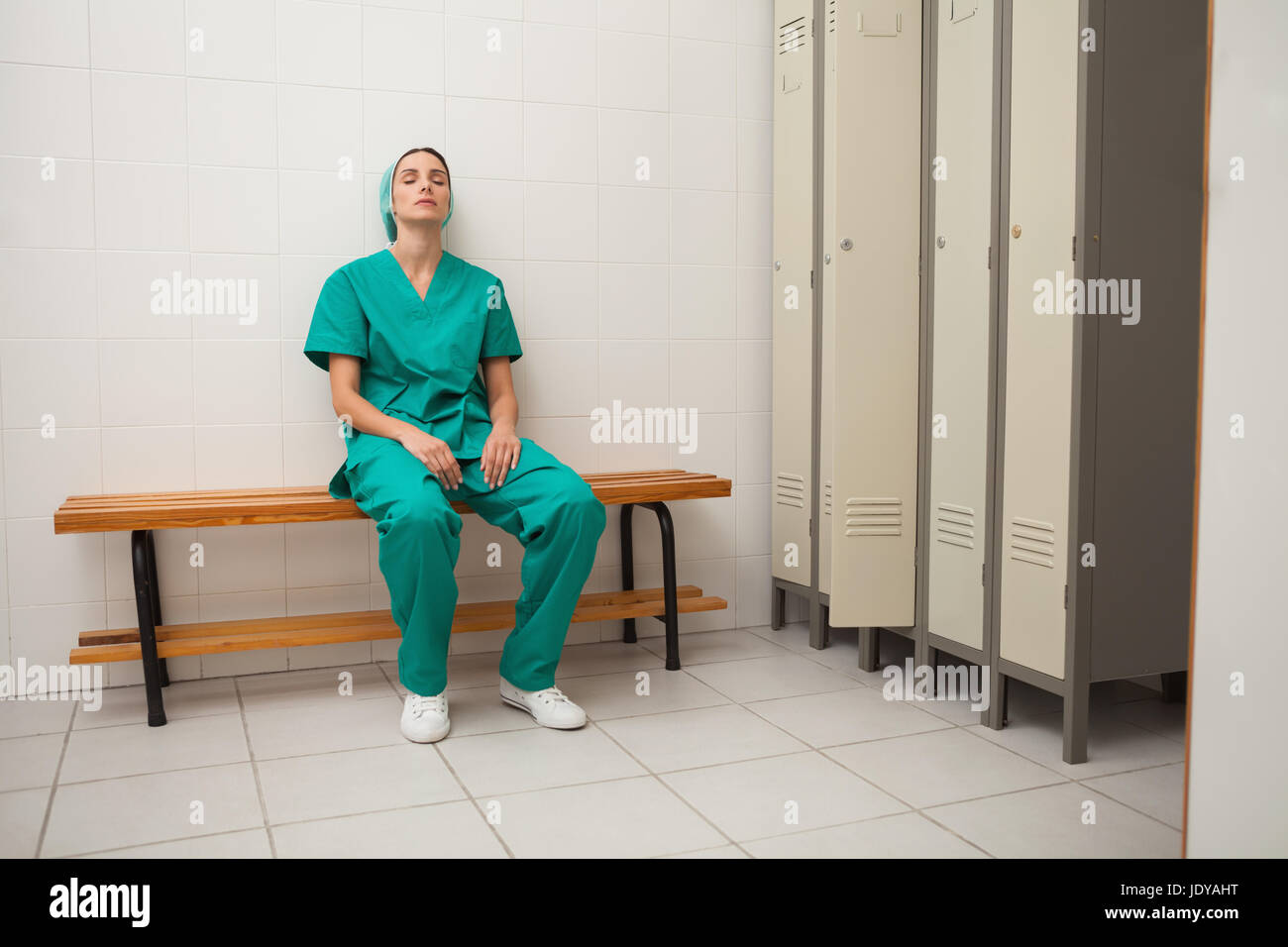 Nurse sitting on a bench in locker room Stock Photo - Alamy