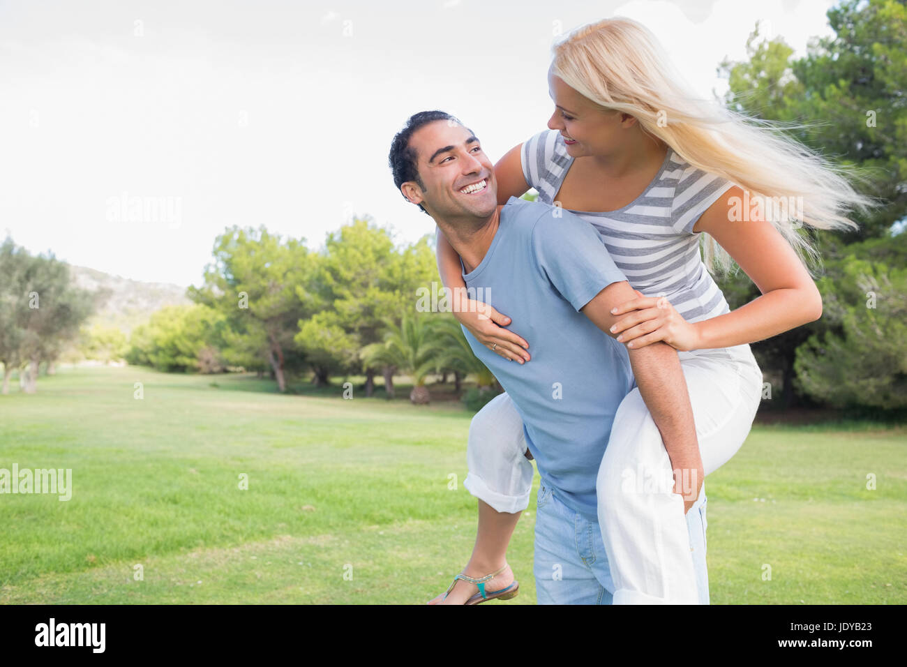 Attractive smiling couple having fun in the park Stock Photo - Alamy