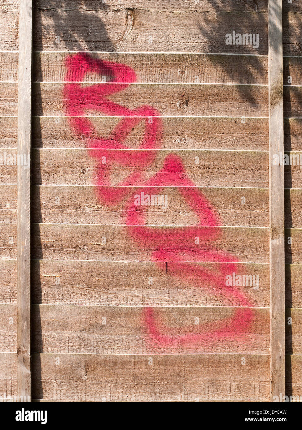 a red spray paint stain outside on a wooden garden fence Stock Photo
