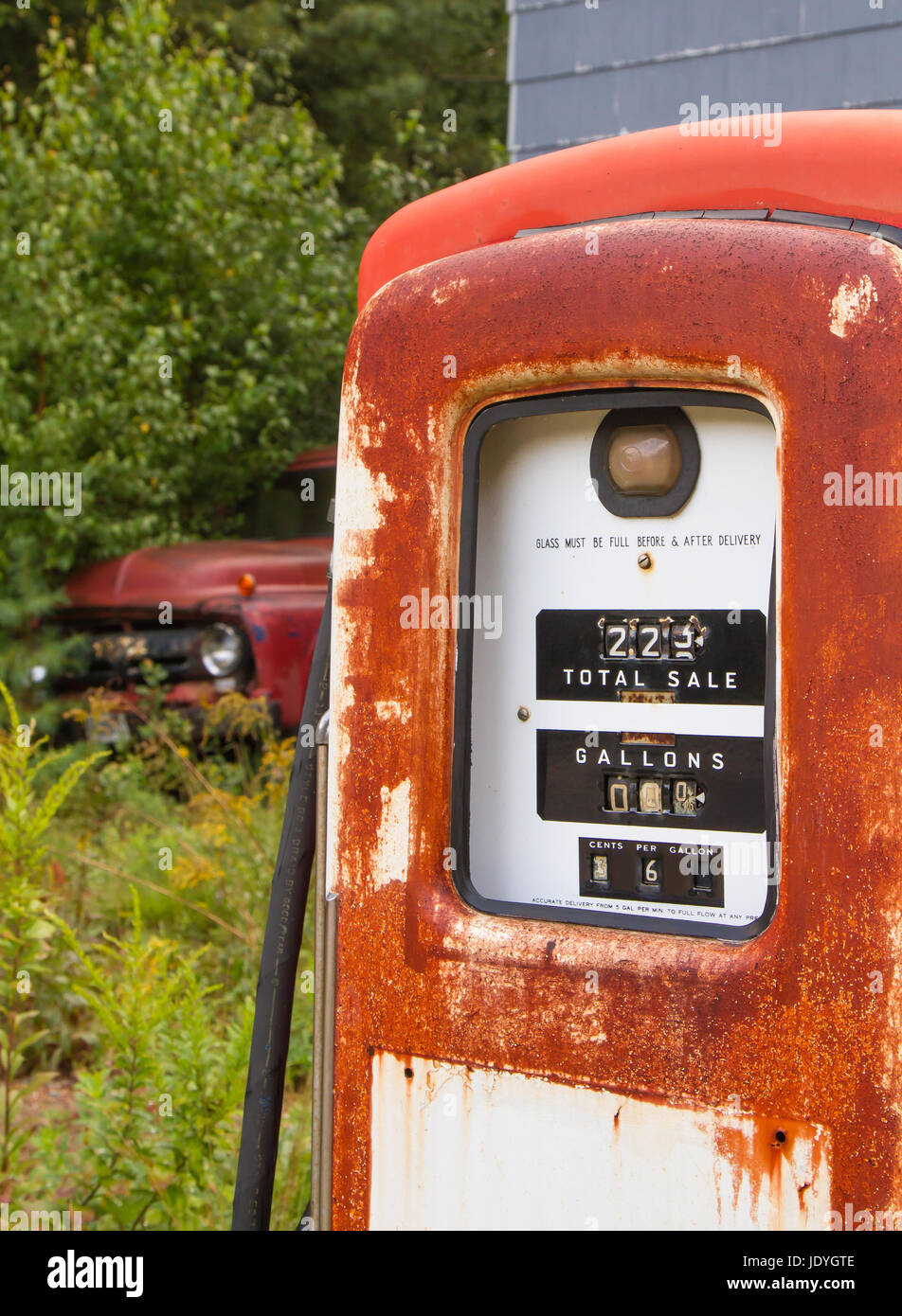 Old 1950s gas pump at an abandoned service station with pick-up truck in the background. Stock Photo