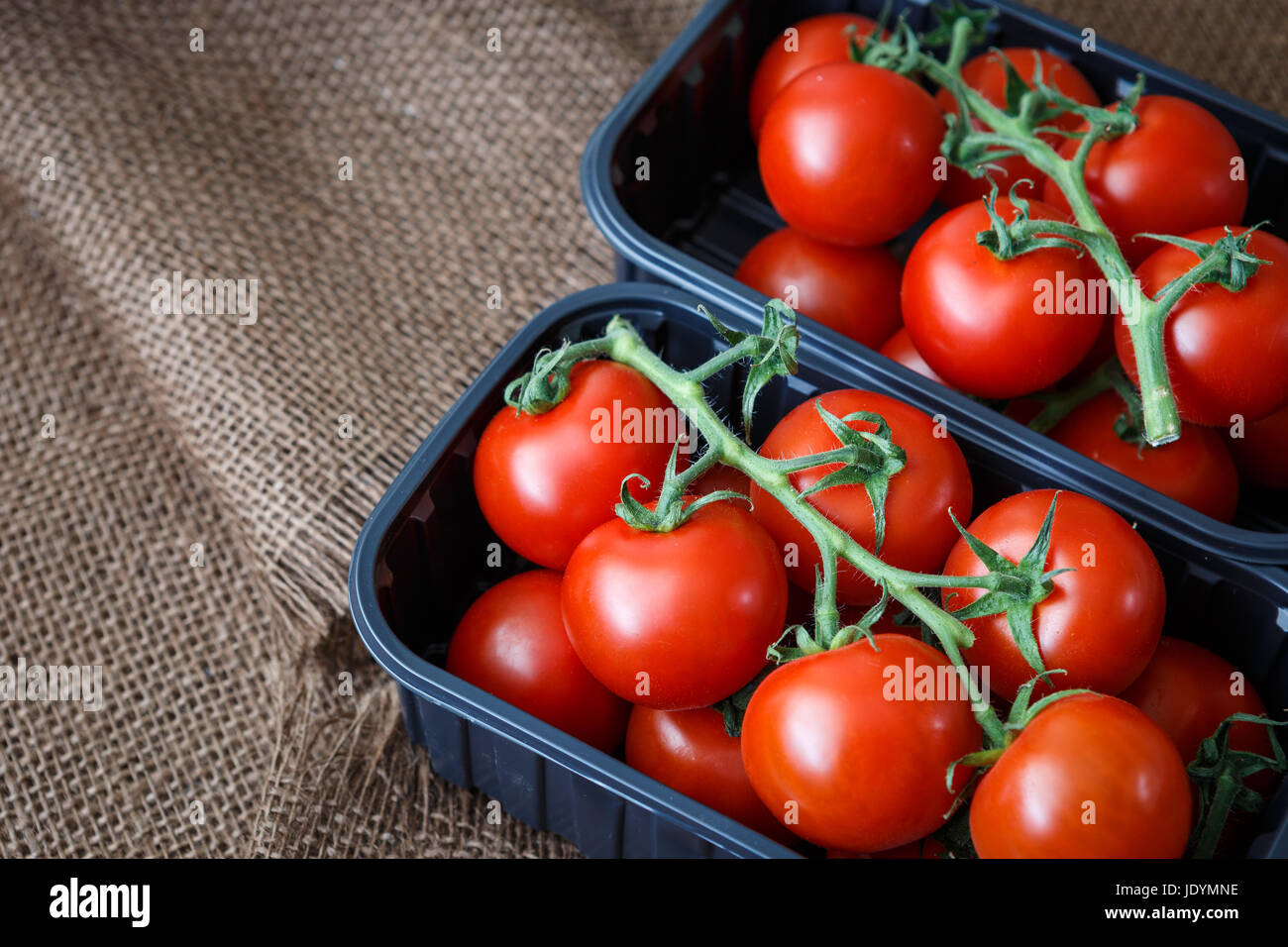 Green red tomatoes in a vegetable box and a black hi-res stock ...
