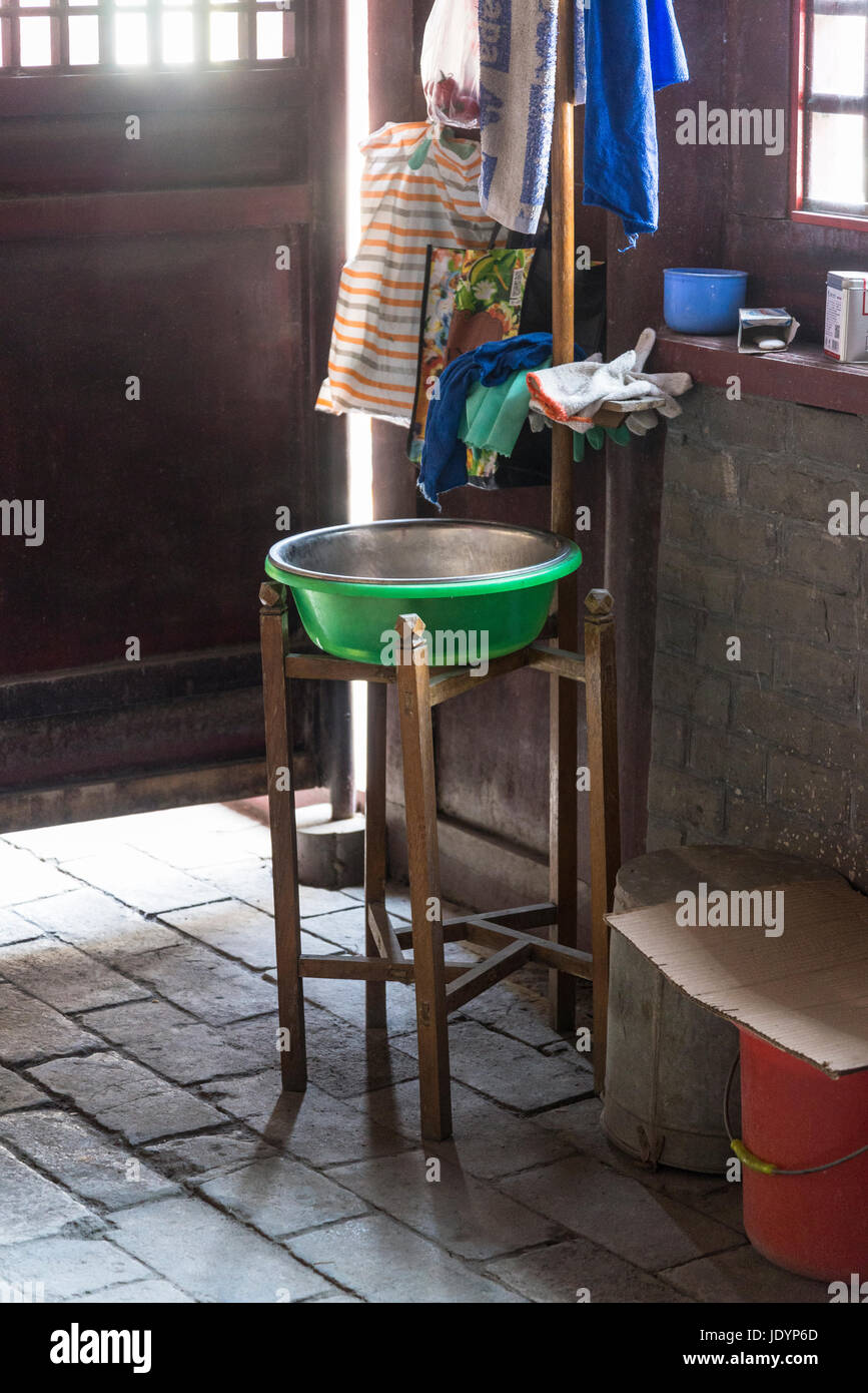 Modest room with cleaning materials and traditional washing bowl on a stand, Qufu, Shandong province, the hometown of Confucius, China Stock Photo