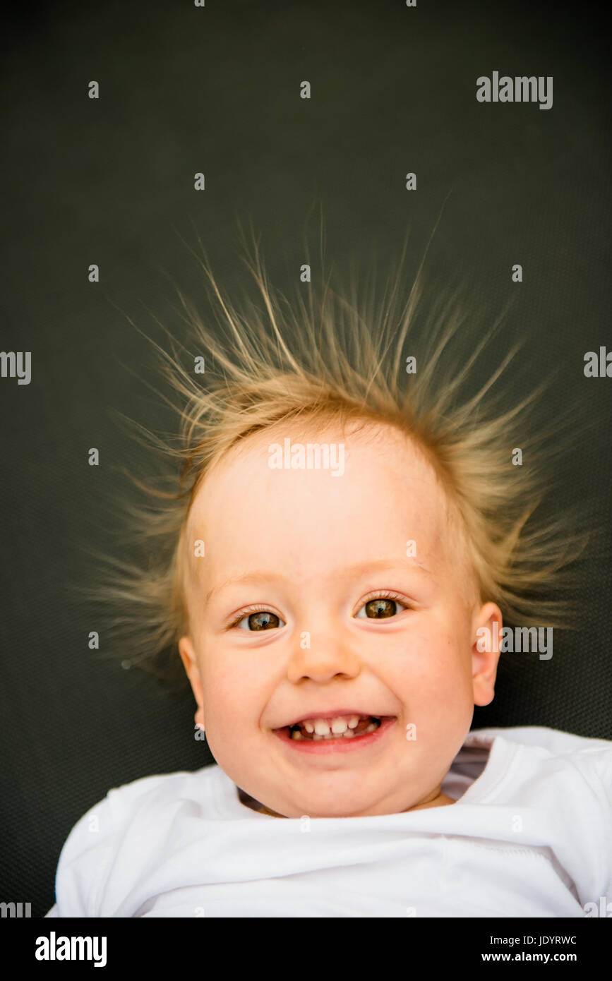 Portrait of smiling baby with standing hair from static electricity