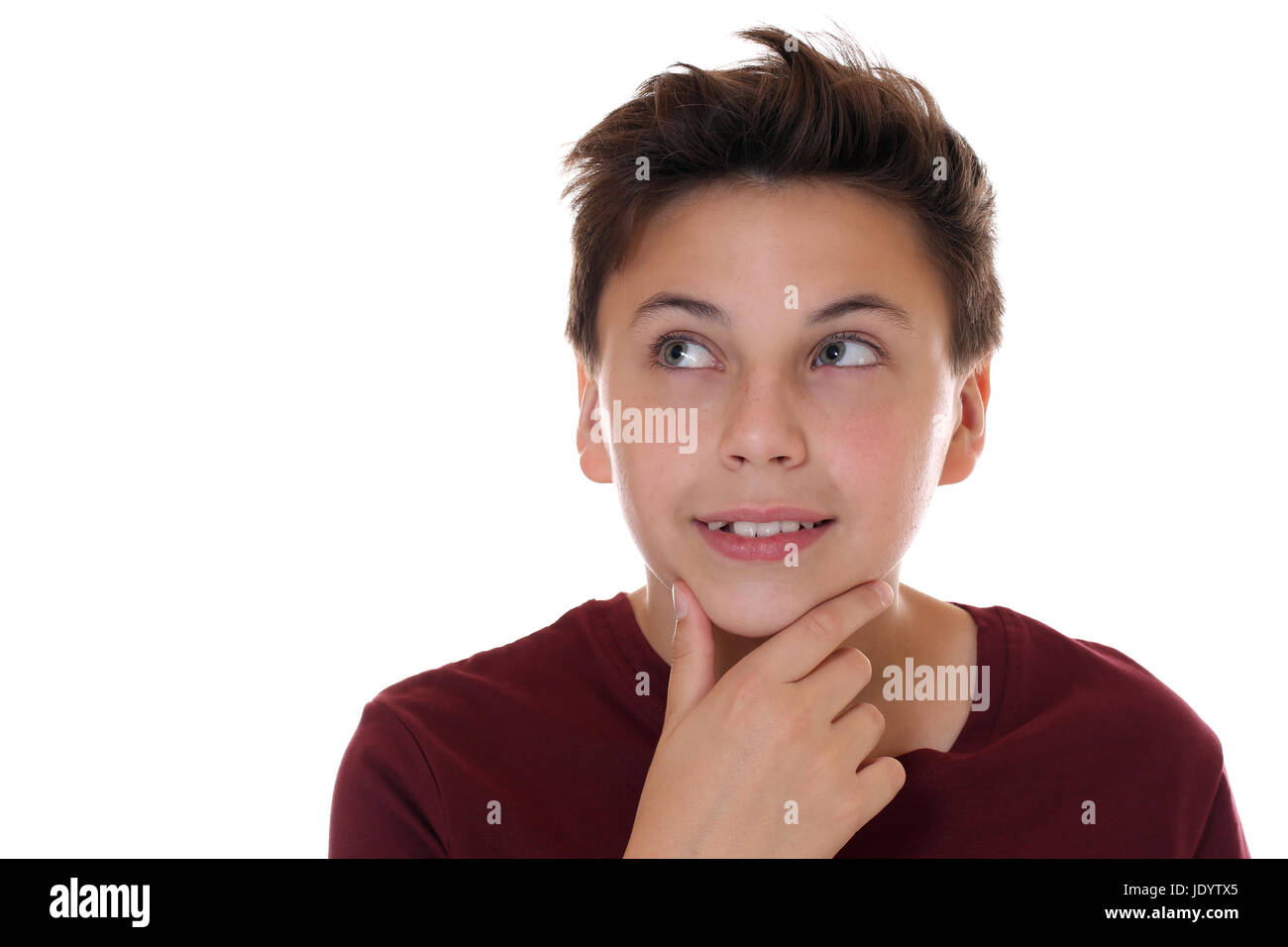 Junger Teenager beim Denken oder Träumen, isoliert vor einem weissen Hintergrund Stock Photo