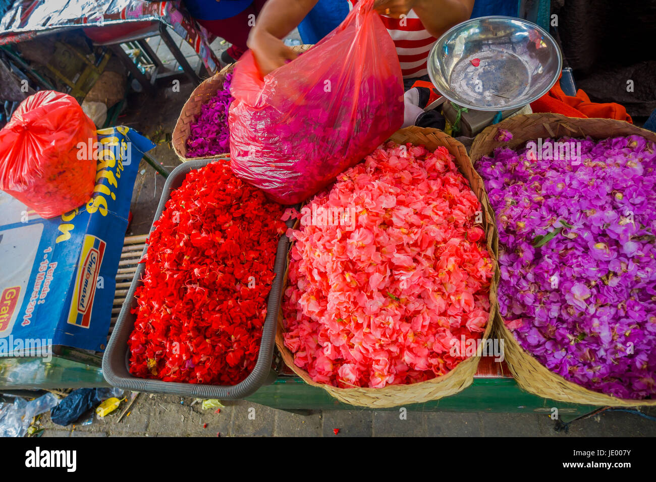 Outdoor Bali flower market. Flowers are used daily by Balinese Hindus as symbolic offerings at temples, inside of colorful baskets. Stock Photo