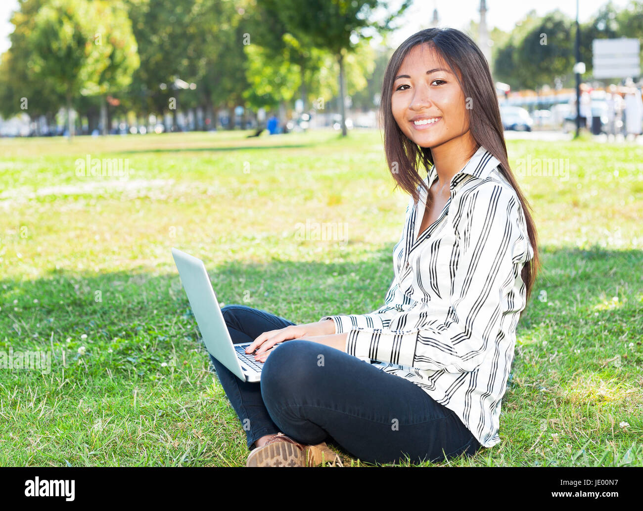 Pretty asian girl on laptop sitting on the grass Stock Photo - Alamy