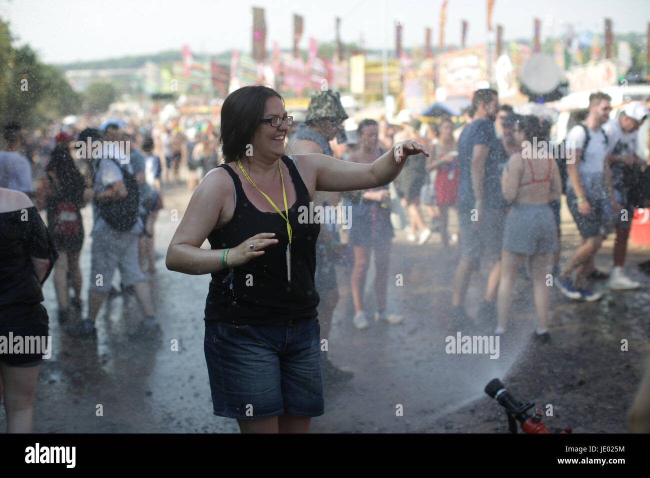 Somerset, UK. 21st June, 2017. A woman is doused by Shepton Mallet firemen on a very hot Day 1 (Wednesday) of the 2017 Glastonbury Festival at Worthy Farm in Somerset. Photo date: Wednesday, June 21, 2017. Credit: Roger Garfield/Alamy Live News Stock Photo