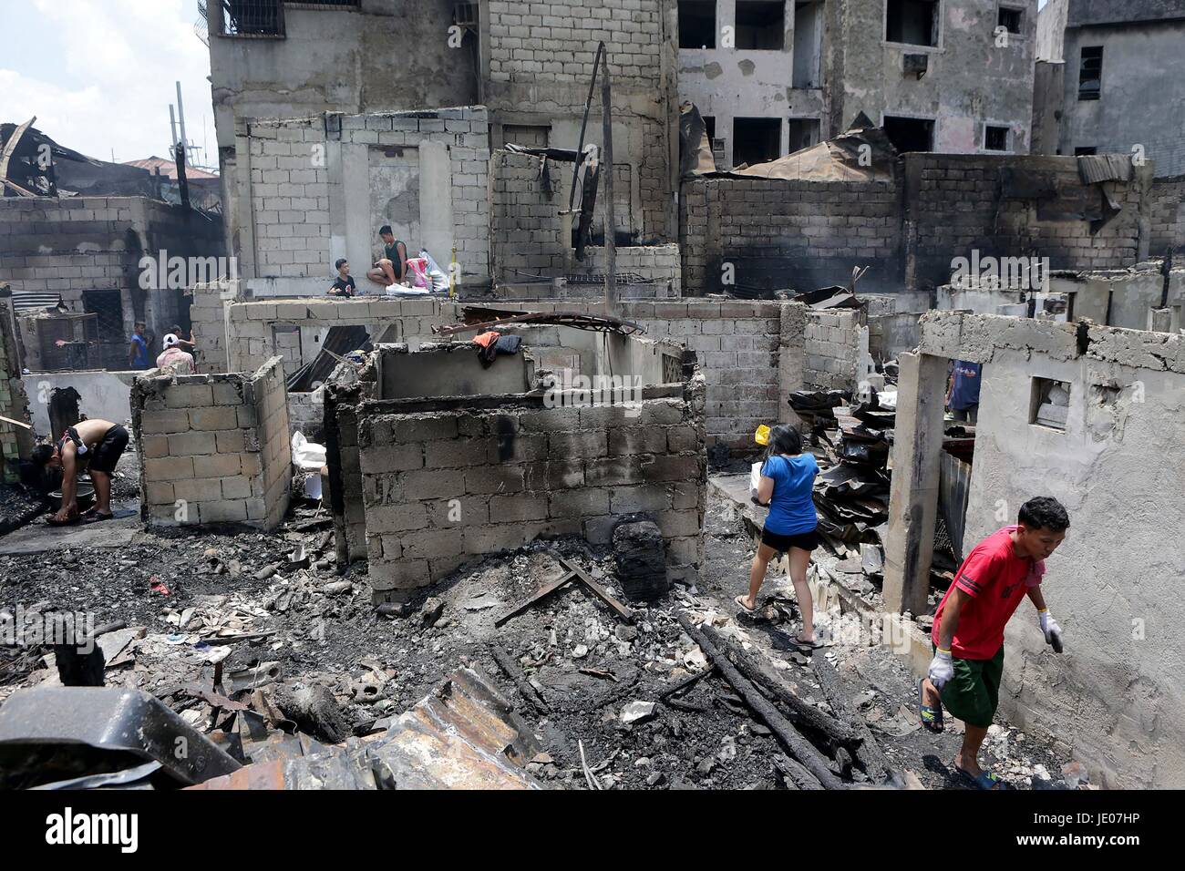 Manila, Philippines. 22nd June, 2017. Residents look for reusable materials from their burnt home after a fire at a residential area in Manila, the Philippines, June 22, 2017. More than 100 shanties were razed in the fire, leaving 200 families homeless. Credit: Rouelle Umali/Xinhua/Alamy Live News Stock Photo