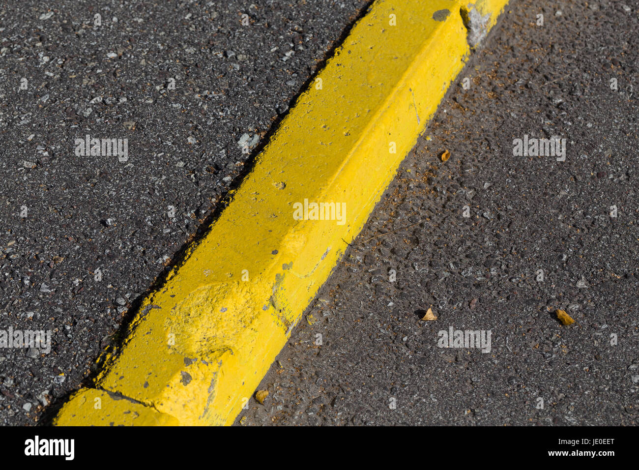 Yellow curb stone border and asphalt road Stock Photo Alamy