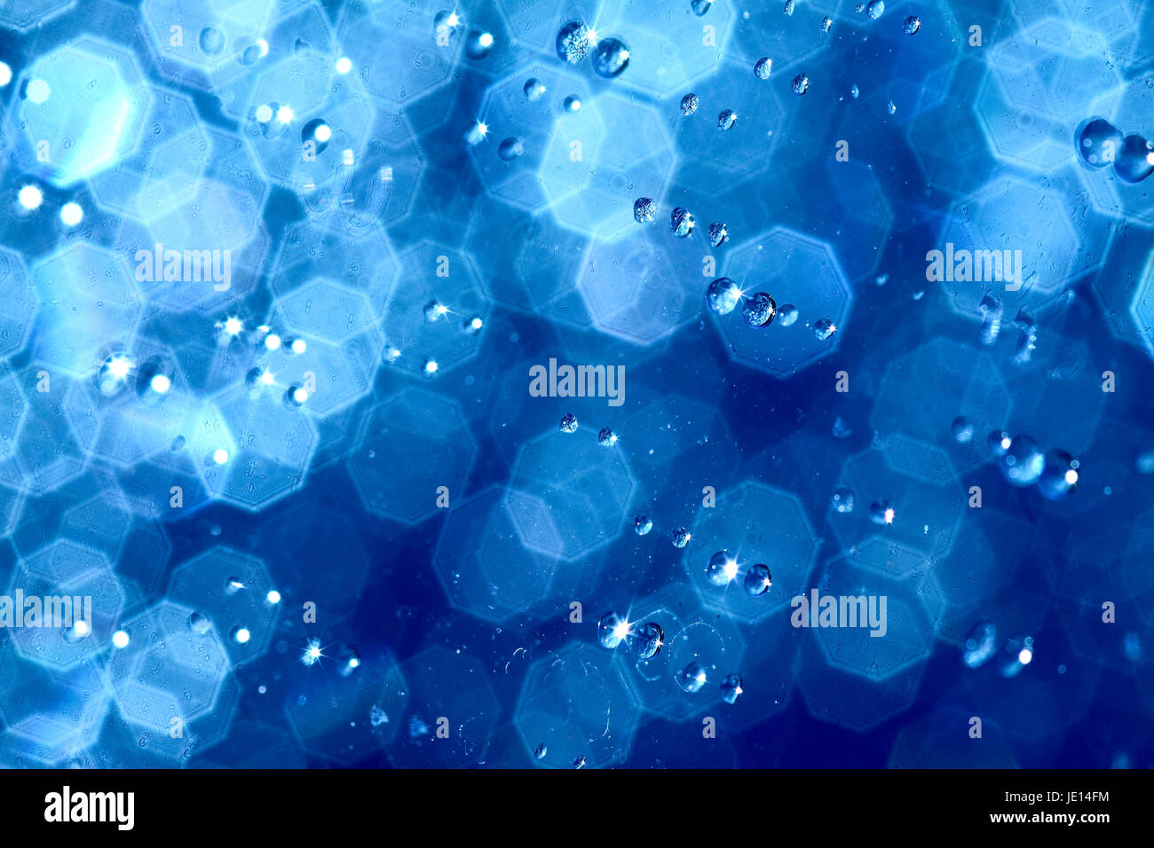 Water drops on a mirror creating a blue abstract pattern and out of ...