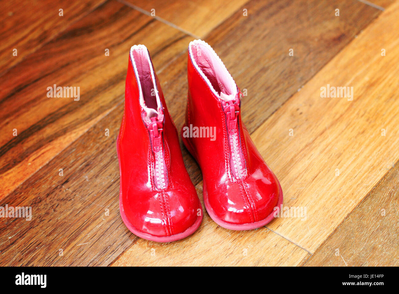 Little pair of red patent toddler boots with a zip up the front Stock Photo