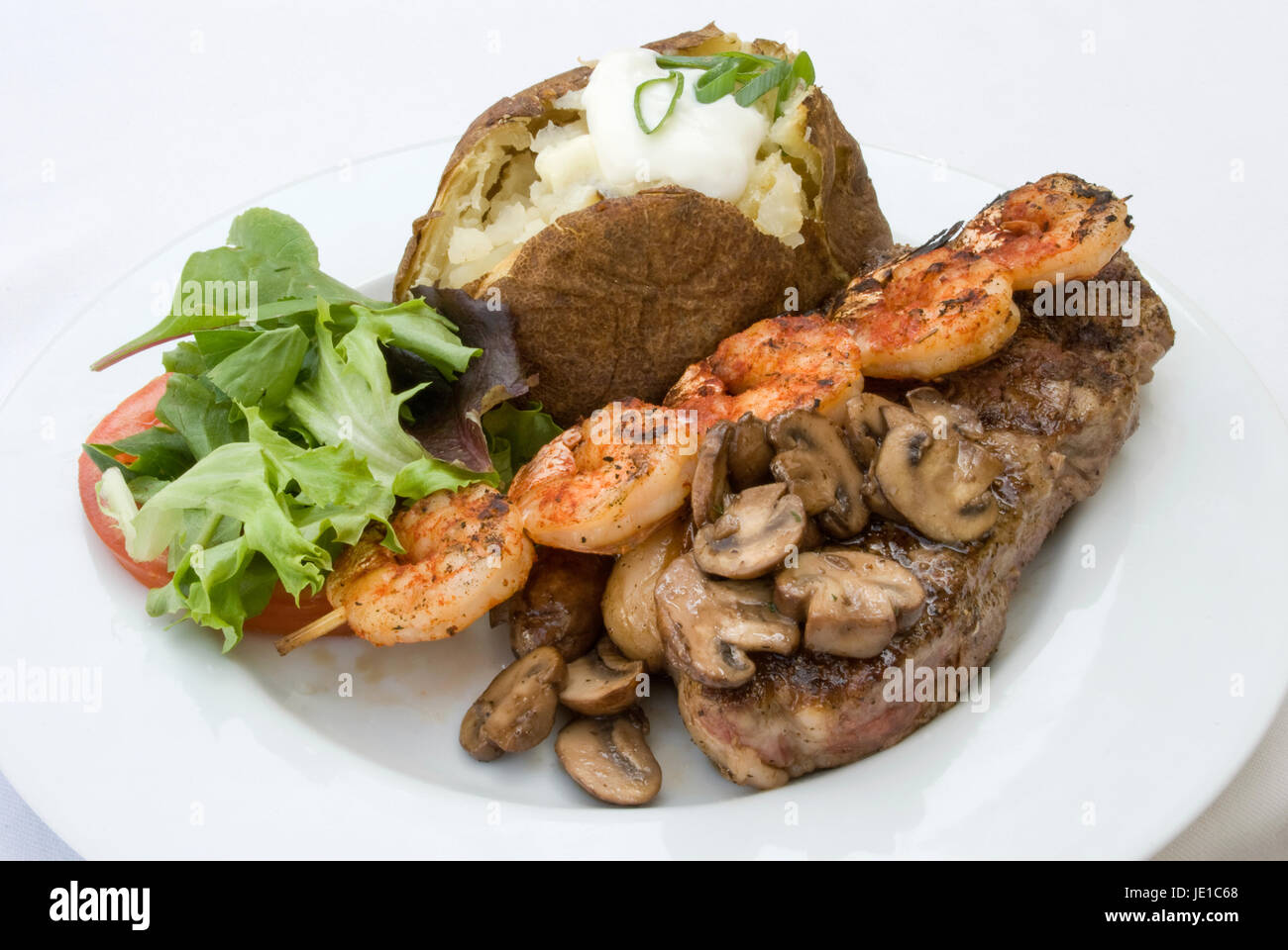 Gourmet dinner of Steak, grilled shrimp, mushrooms, loaded baked potato