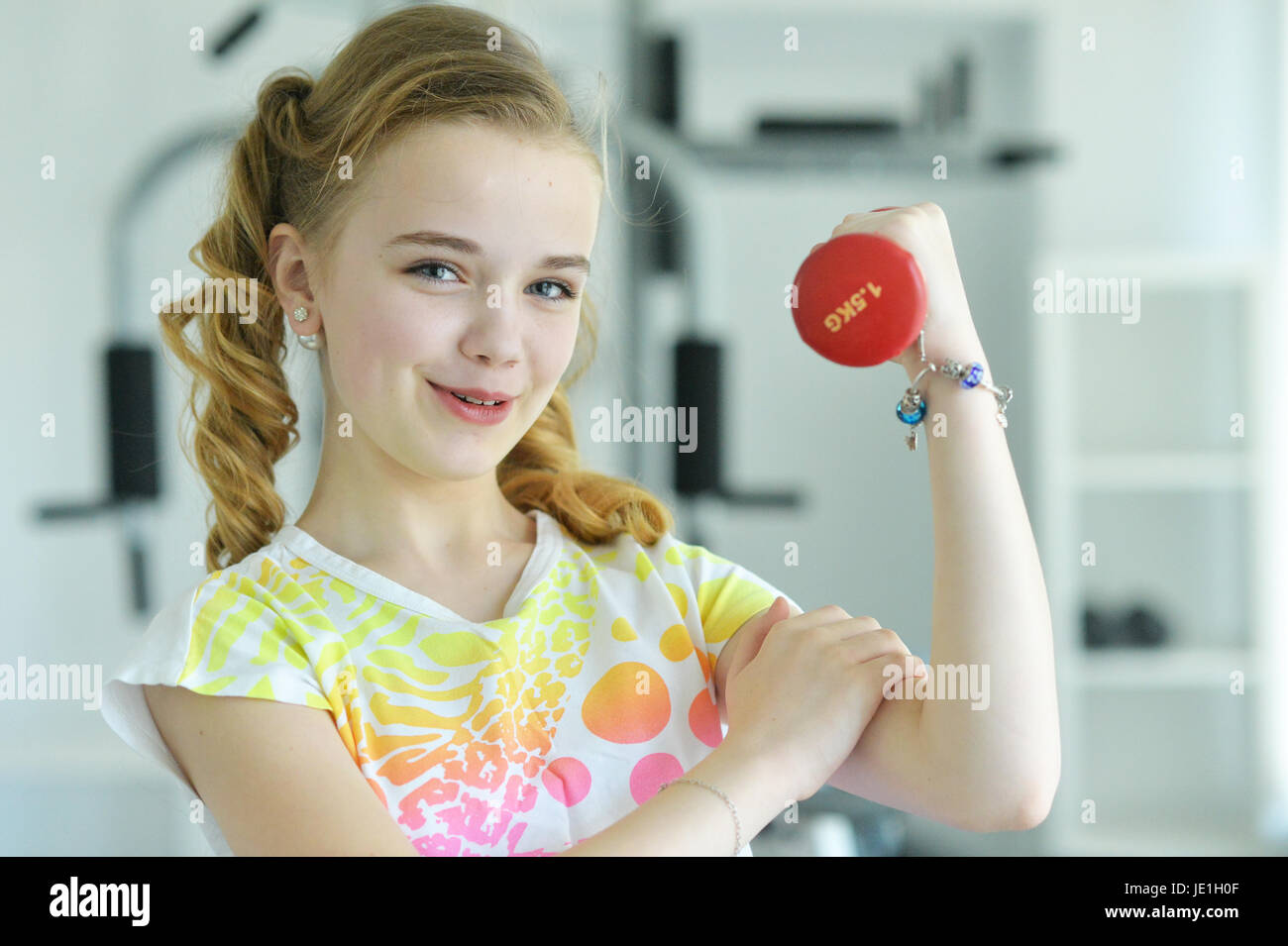 Cute little girl doing exercises with dumbbells Stock Photo - Alamy