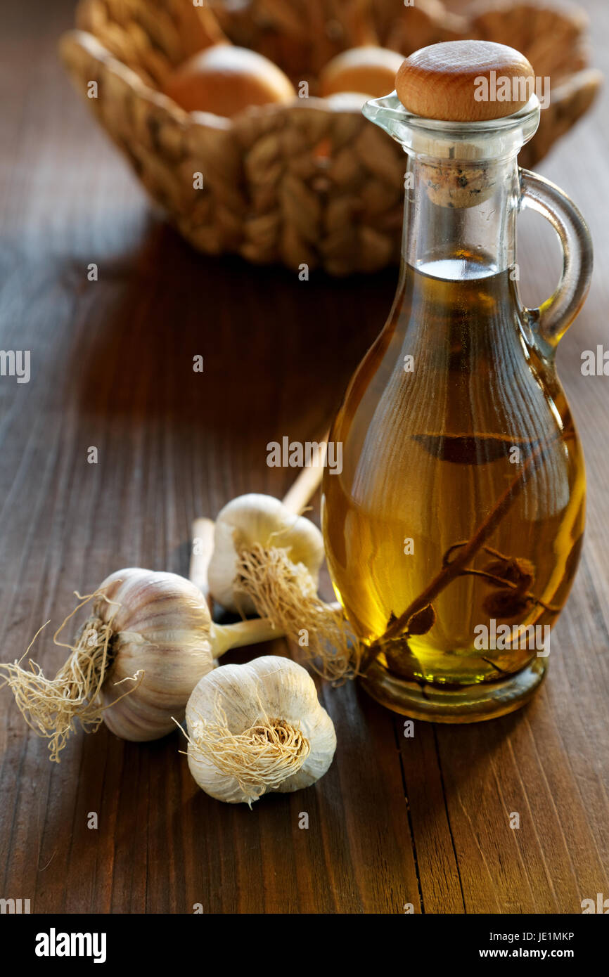 head of garlic and olive oil bottle on a rustic table Stock Photo