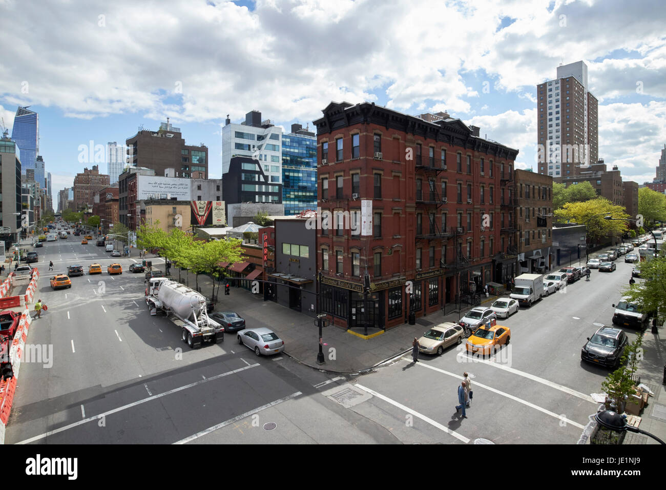 looking up tenth avenue and west 17th street junction through chelsea with old tenement building on the corner New York City USA Stock Photo