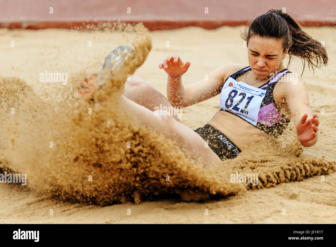 woman athlete landing in sand long jump during UrFO Championship in athletics Stock Photo