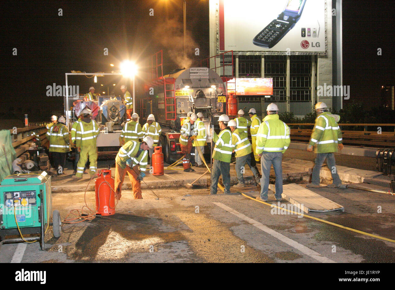 Workmen replace carriageway joints during an overnight closure of the elevated M4 Motorway west of London, UK Stock Photo