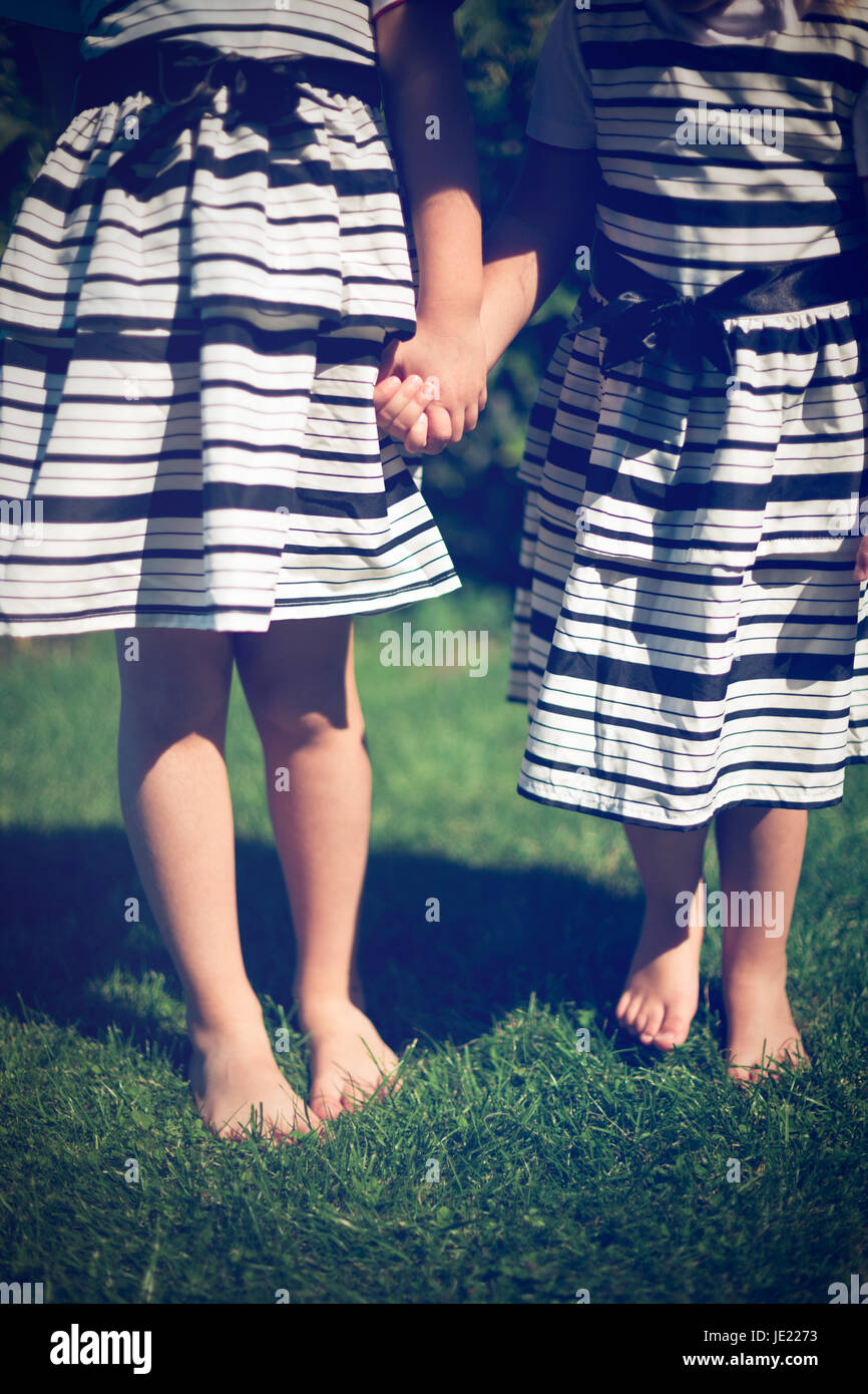 Girls holding hands. Exterior shot Stock Photo - Alamy