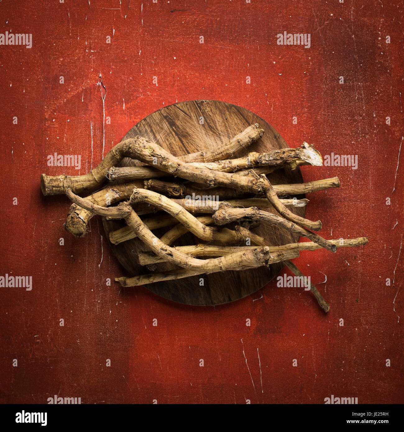 Horseradish root on red vintage background, top view, food backgrounds