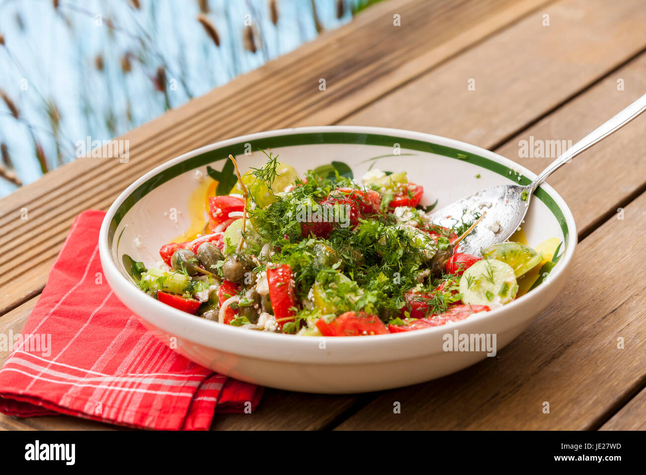 Schüssel mit mariniertem griechischen Salat mit Tomaten käse und oliven auf einem holz untergrund Stock Photo