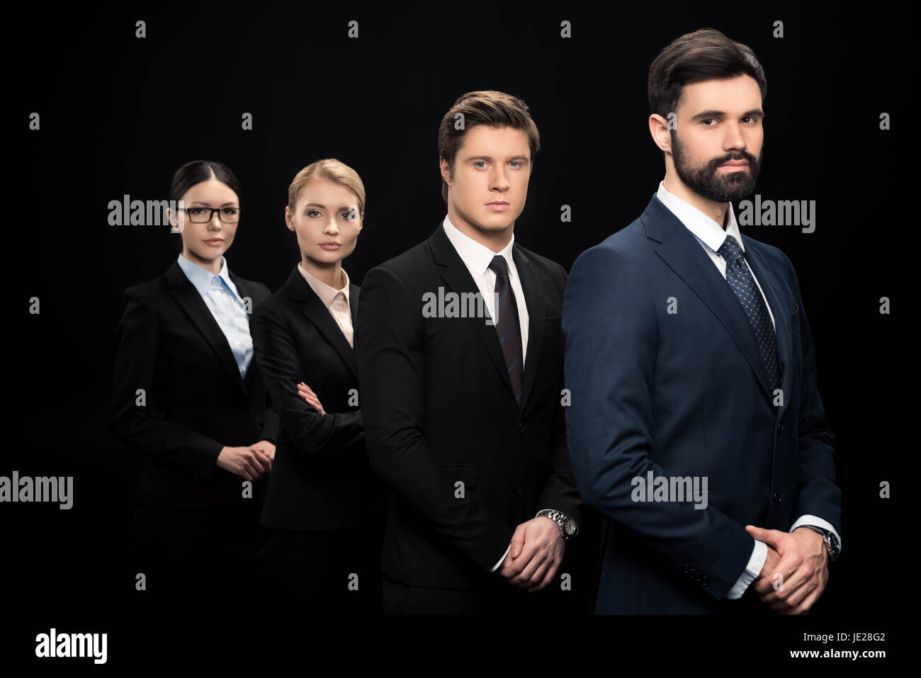 side view of business people standing in row isolated on black Stock ...