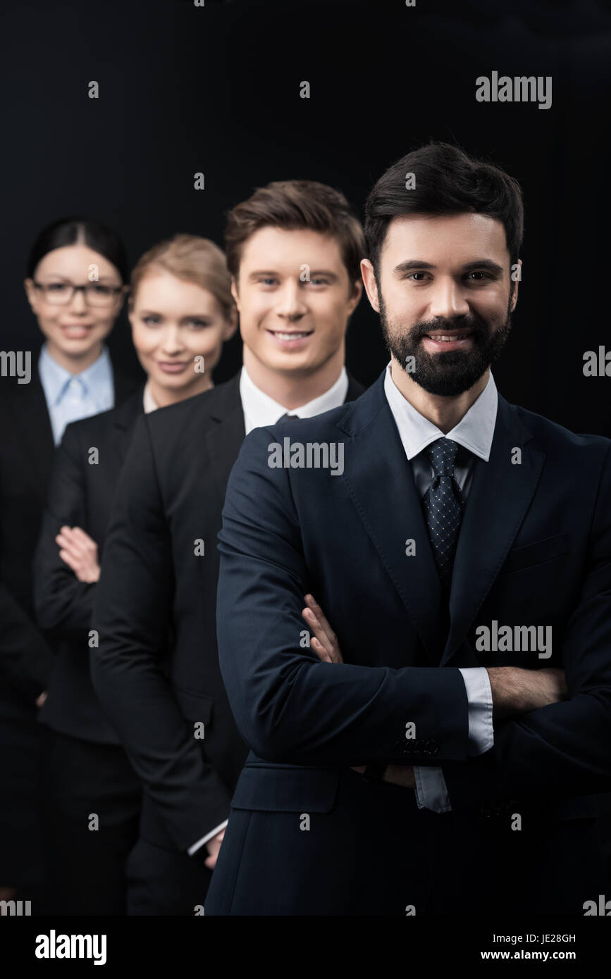 group of confident business people standing in row isolated on black ...