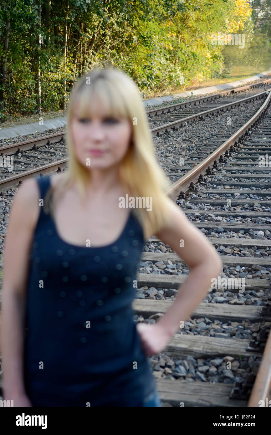 Frau steht  auf Gleis Stock Photo