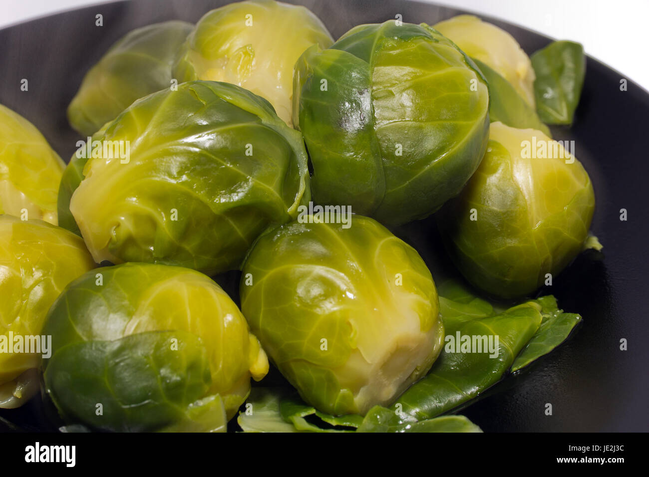 boiled brussel sprouts on the black plater Stock Photo - Alamy
