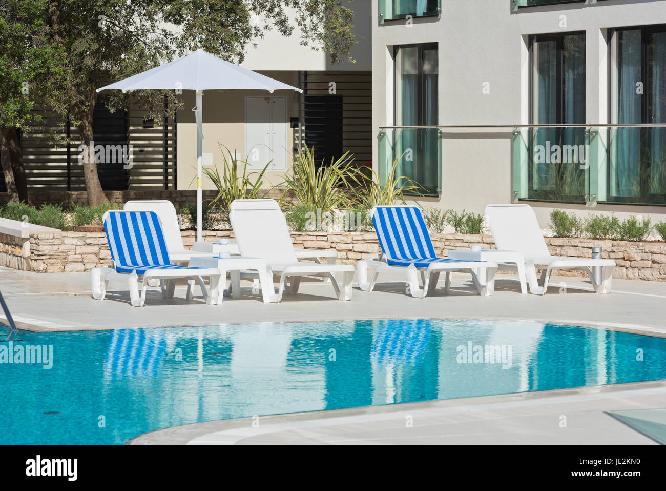 sunbeds and umbrellas by the swimming pool on a sunny day Stock Photo ...