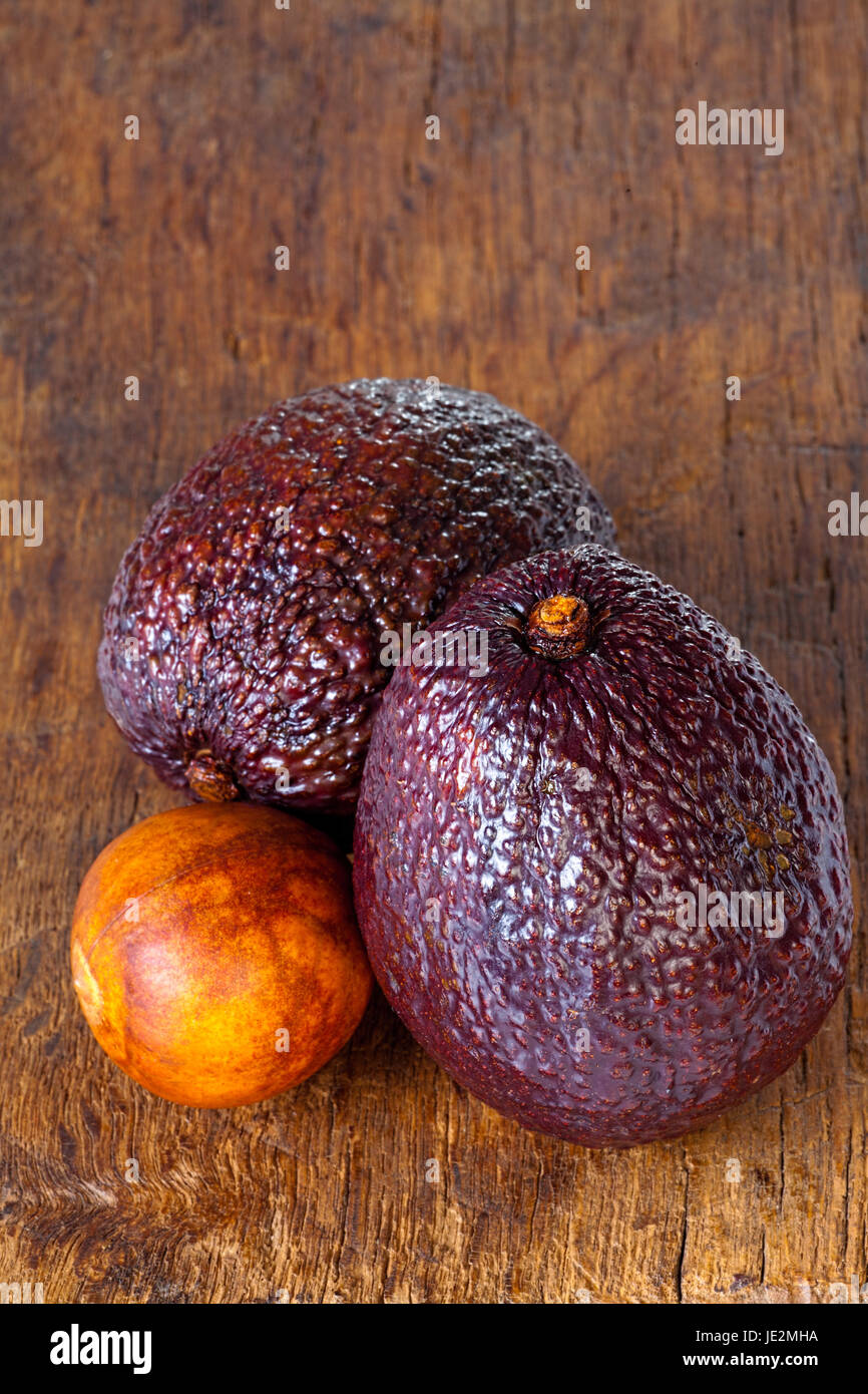 Avocado Stub Ripe Close up view of two ripe avocados and avocado stone on an old rustic ...