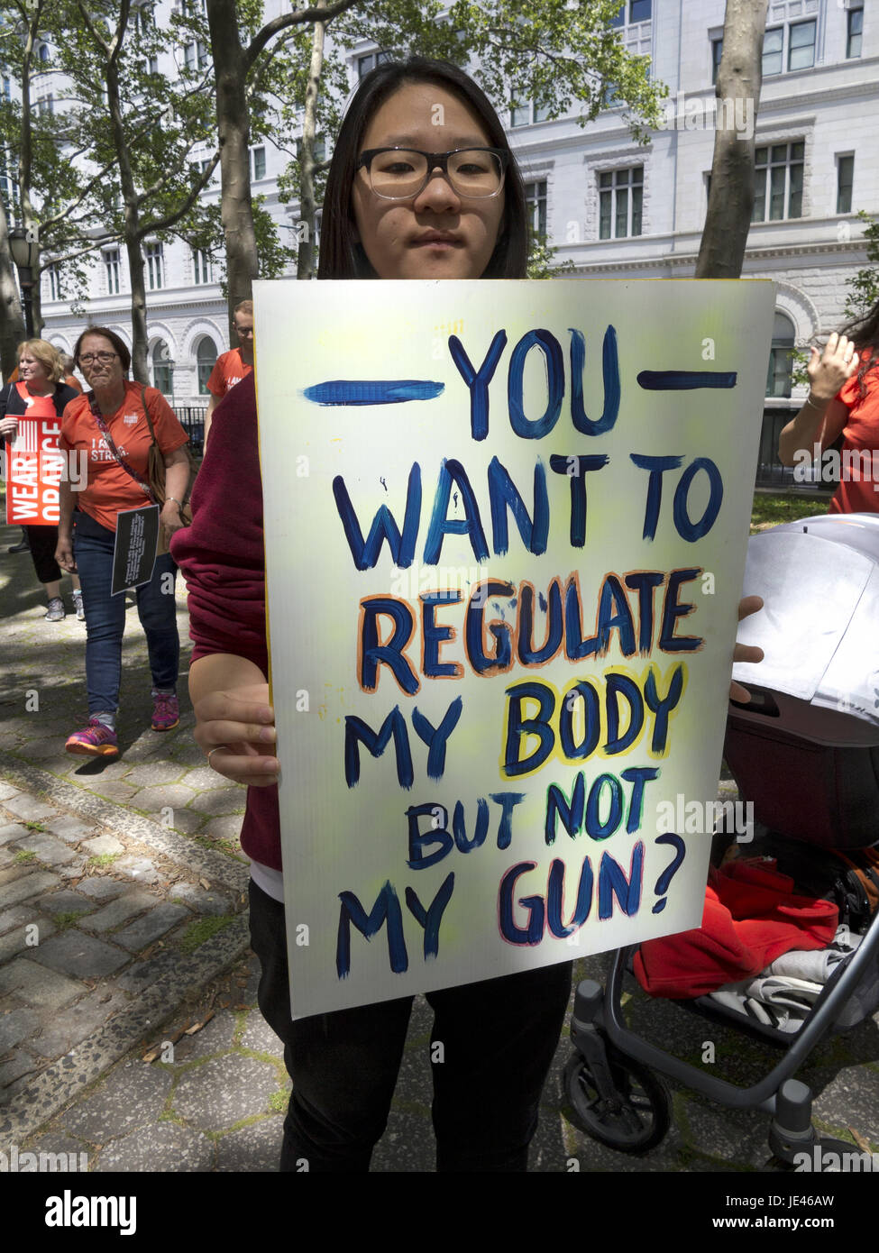 Young woman at Fifth Annual Brooklyn Bridge March for Gun Sense 6/3/17 in NYC. Sign says, 'You Want to Regulate My Body but Not My Gun.' Stock Photo
