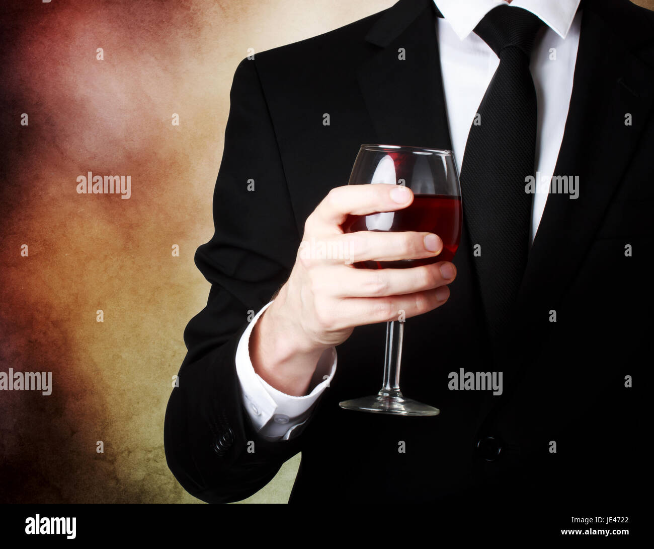 Elegant young man holding a glass of red wine Stock Photo - Alamy
