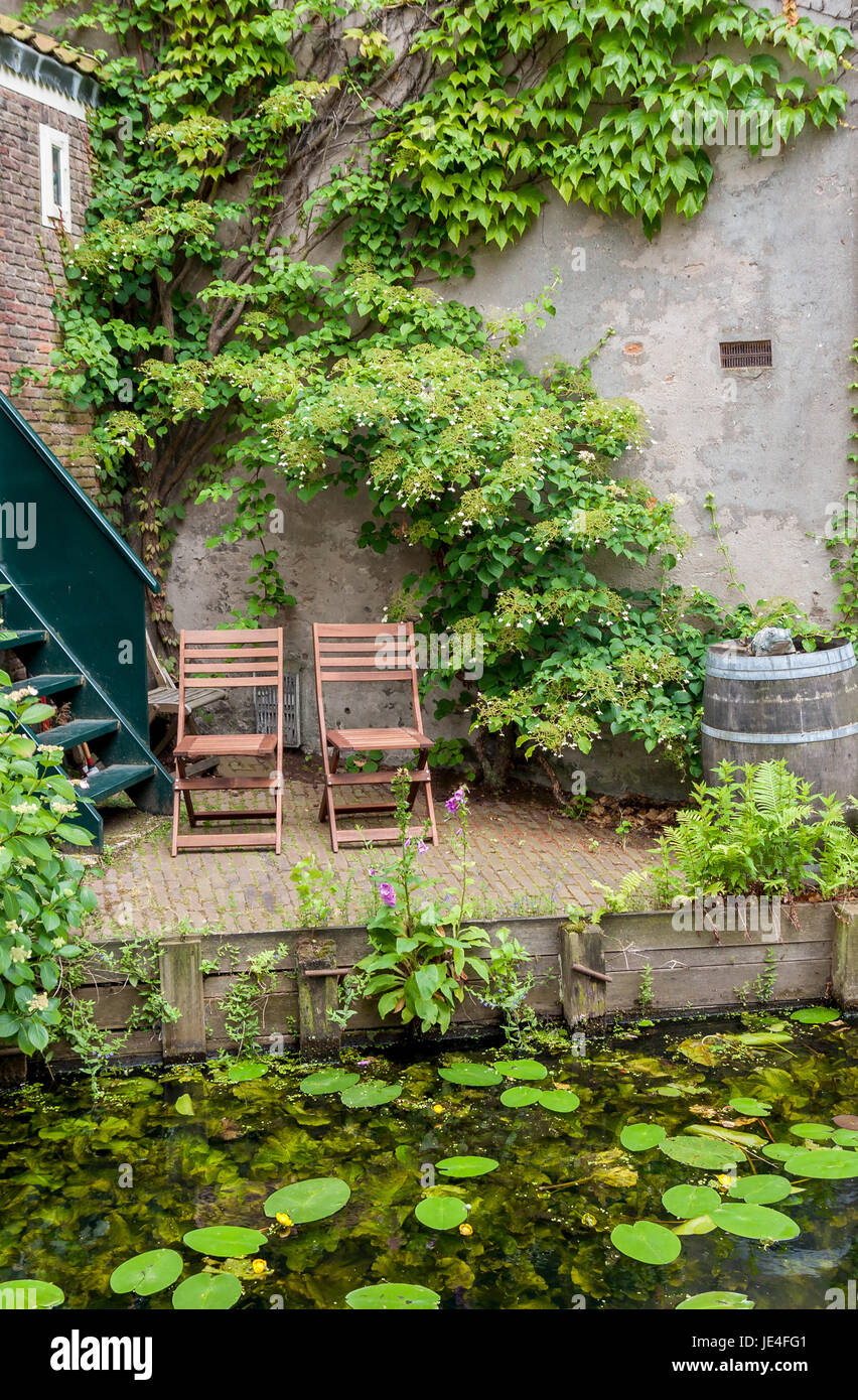 2 Gartenstühle in einer hübschen Sitzecke an einer Gracht in Holland Stock Photo