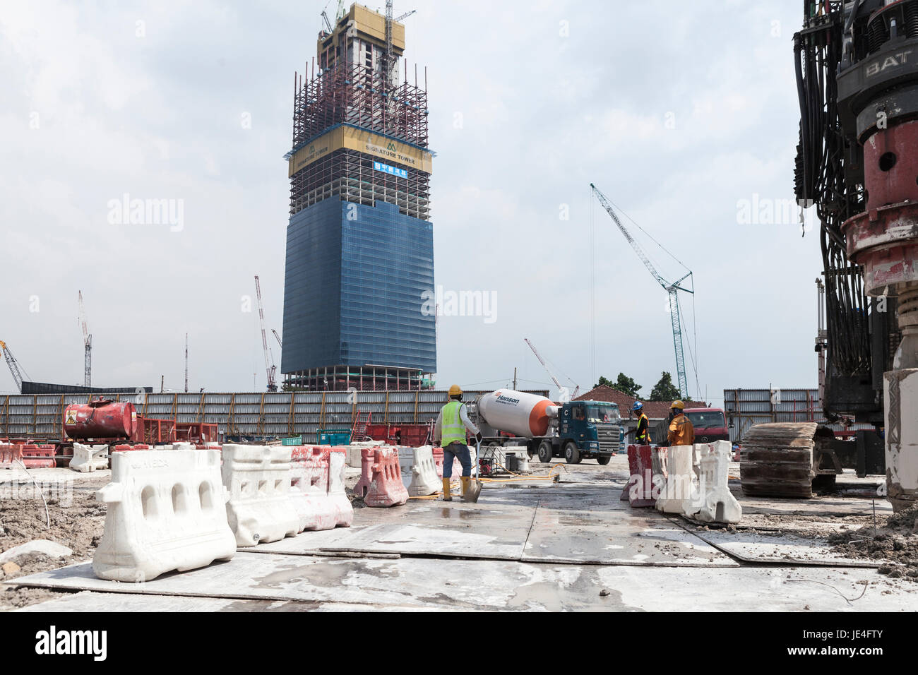 Workers labor near the under construction Signature Tower in the Tun Razak Exchange financial district, developed by TRX City Sdn., in Kuala Lumpur, Malaysia Stock Photo