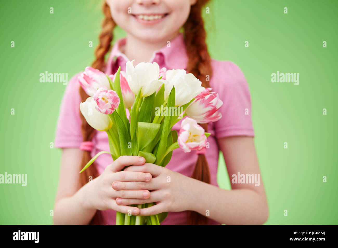 Cute smiling girl holding bunch of tulips Stock Photo - Alamy