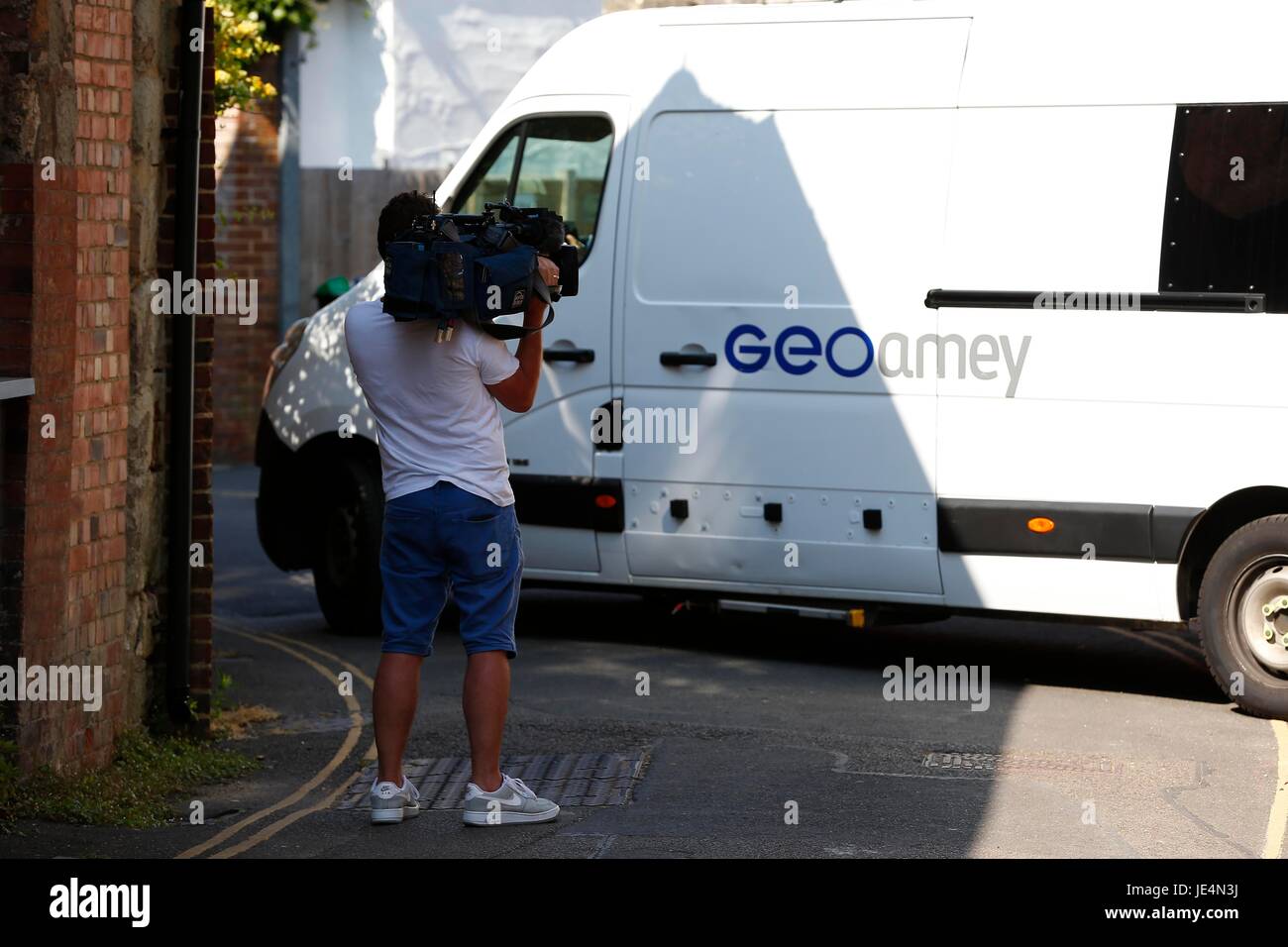 A television news cameraman filmes a Geoamey van transporting prisoners from Lewes Crown Court in East Sussex. Stock Photo