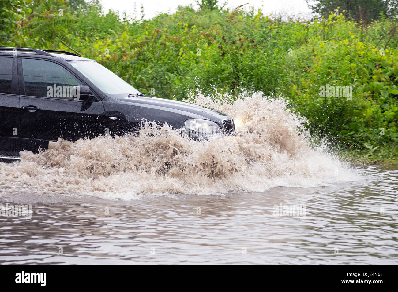 SUV vehicle driving fast through flood water Stock Photo Alamy