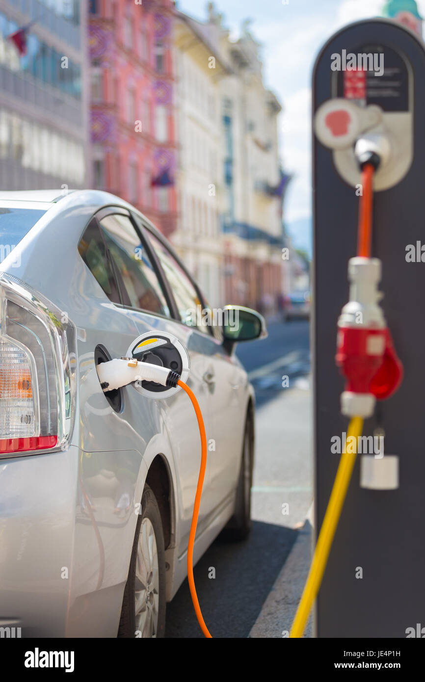 Power supply for electric car charging.  Electric car charging station. Close up of the power supply plugged into an electric car being charged. Stock Photo