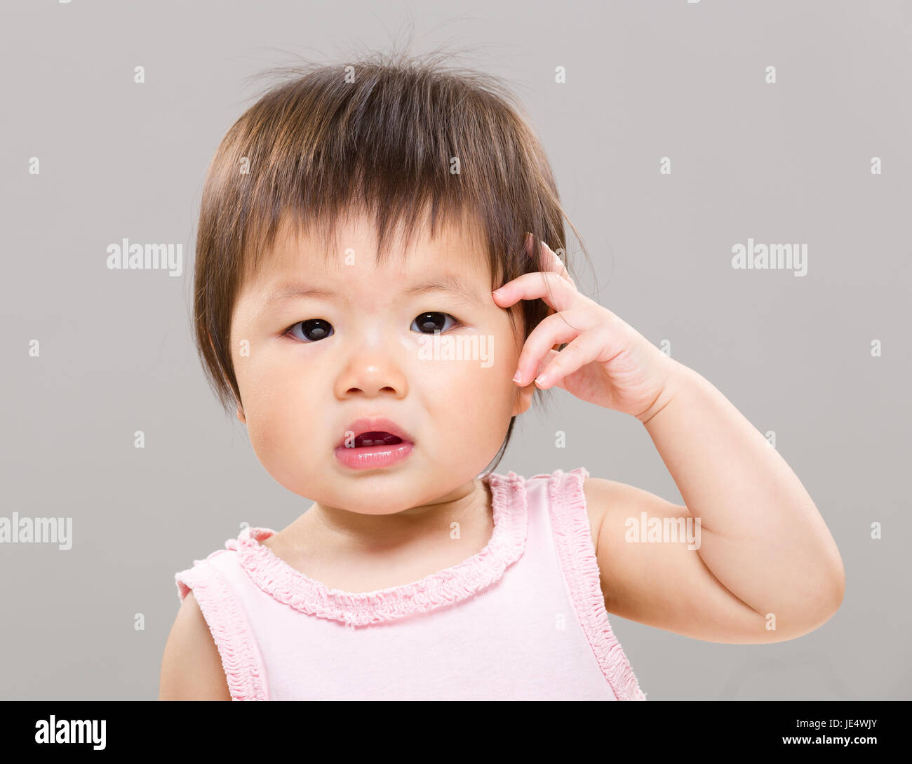 Baby girl scratching head Stock Photo Alamy
