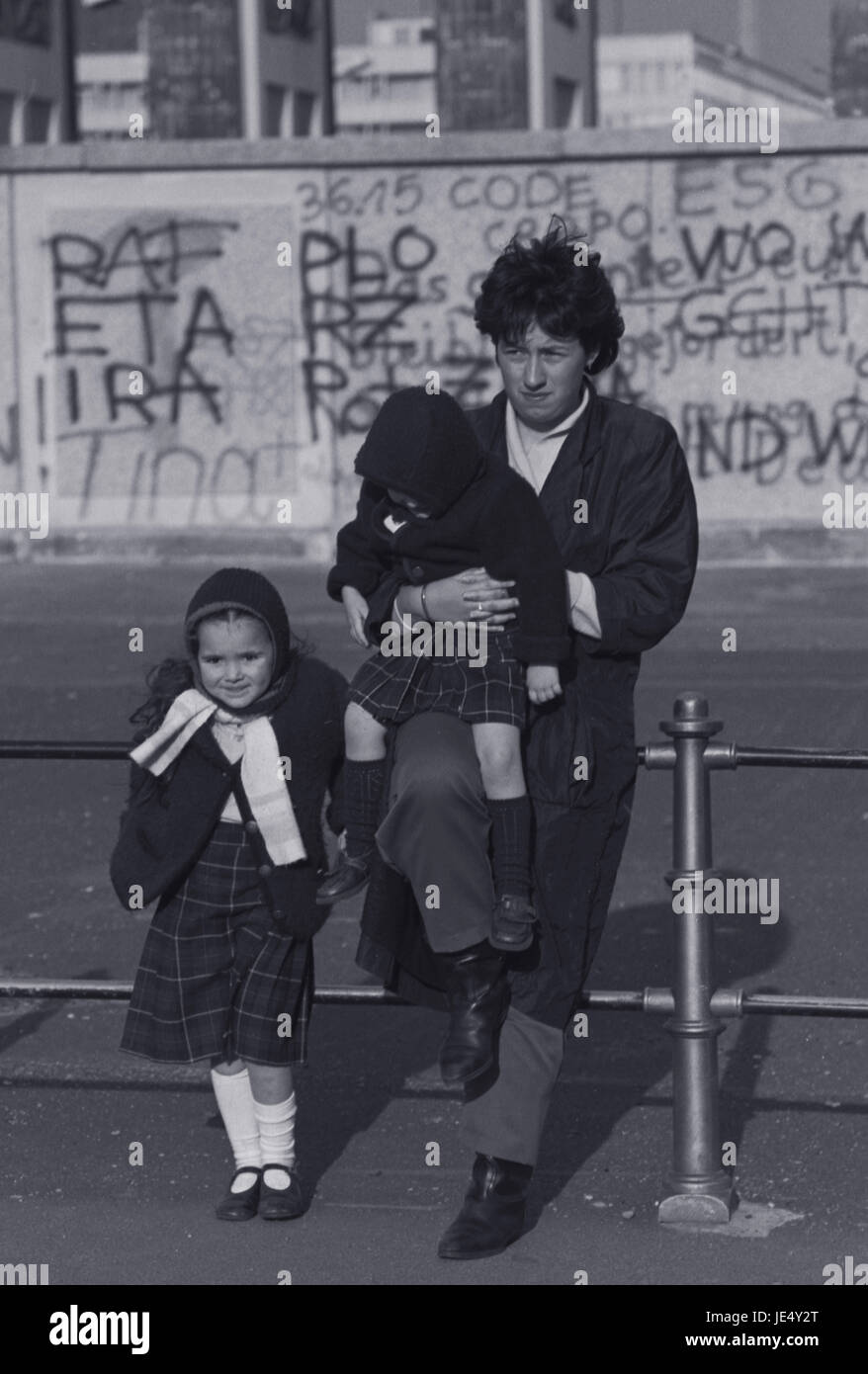 A mother and her children have their photograph taken in front of the Berlin Wall. Stock Photo