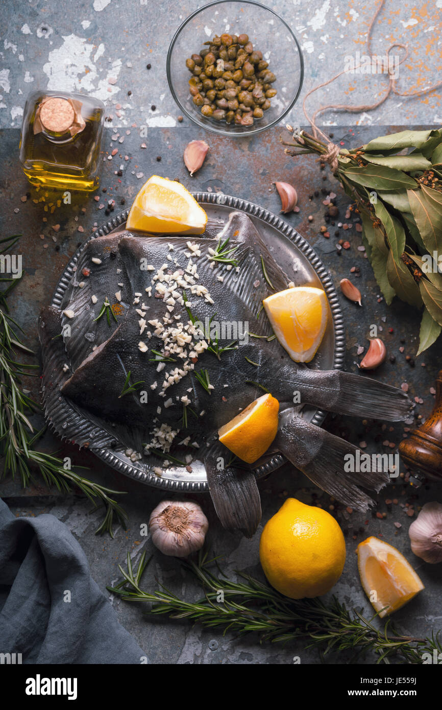Still life with raw flounders and seasoning vertical Stock Photo