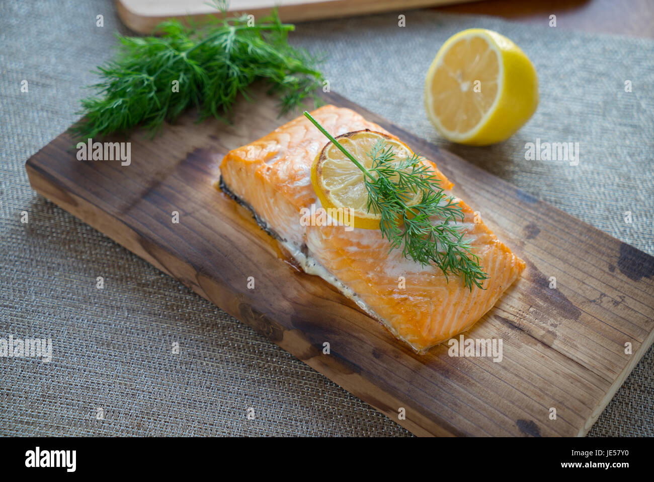 Fresh salmon on cedar plank with dill and lemon. Stock Photo