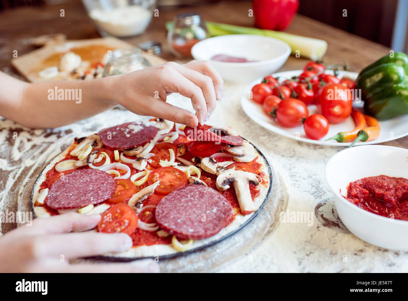 partial view of child putting sausages on pizza Stock Photo Alamy