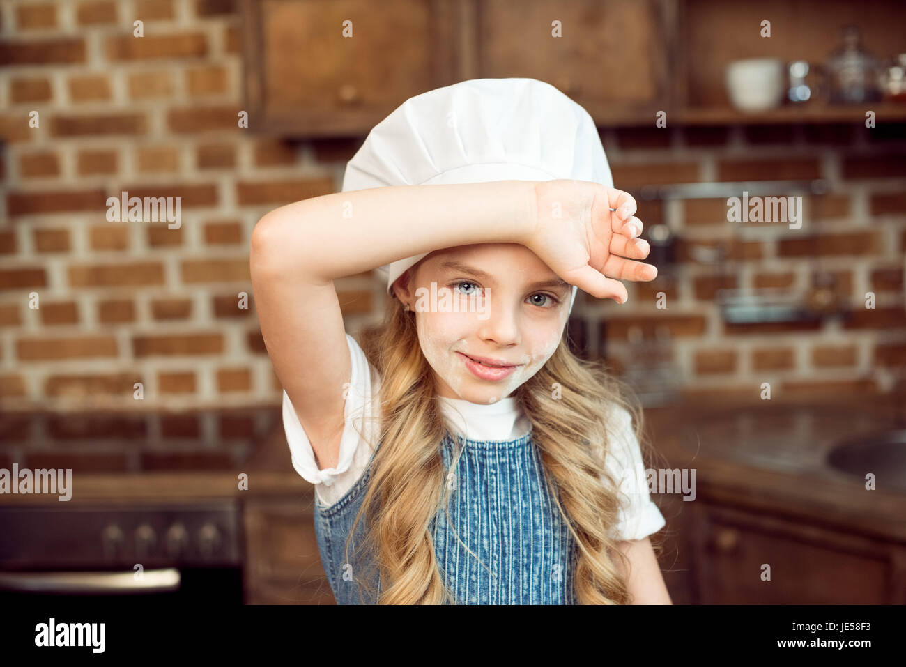 portrait of little girl in chef hat and flour on face Stock Photo - Alamy