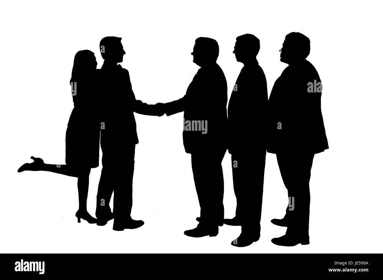 Silhouetted businessmen in a shaking hand pose. Stock Photo