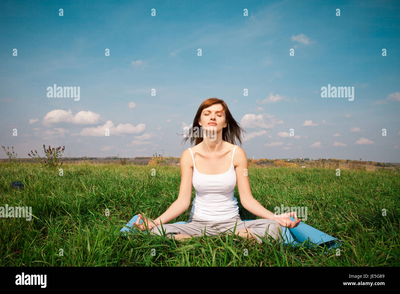 Young girl doing yoga lotus pose in the park Stock Photo - Alamy