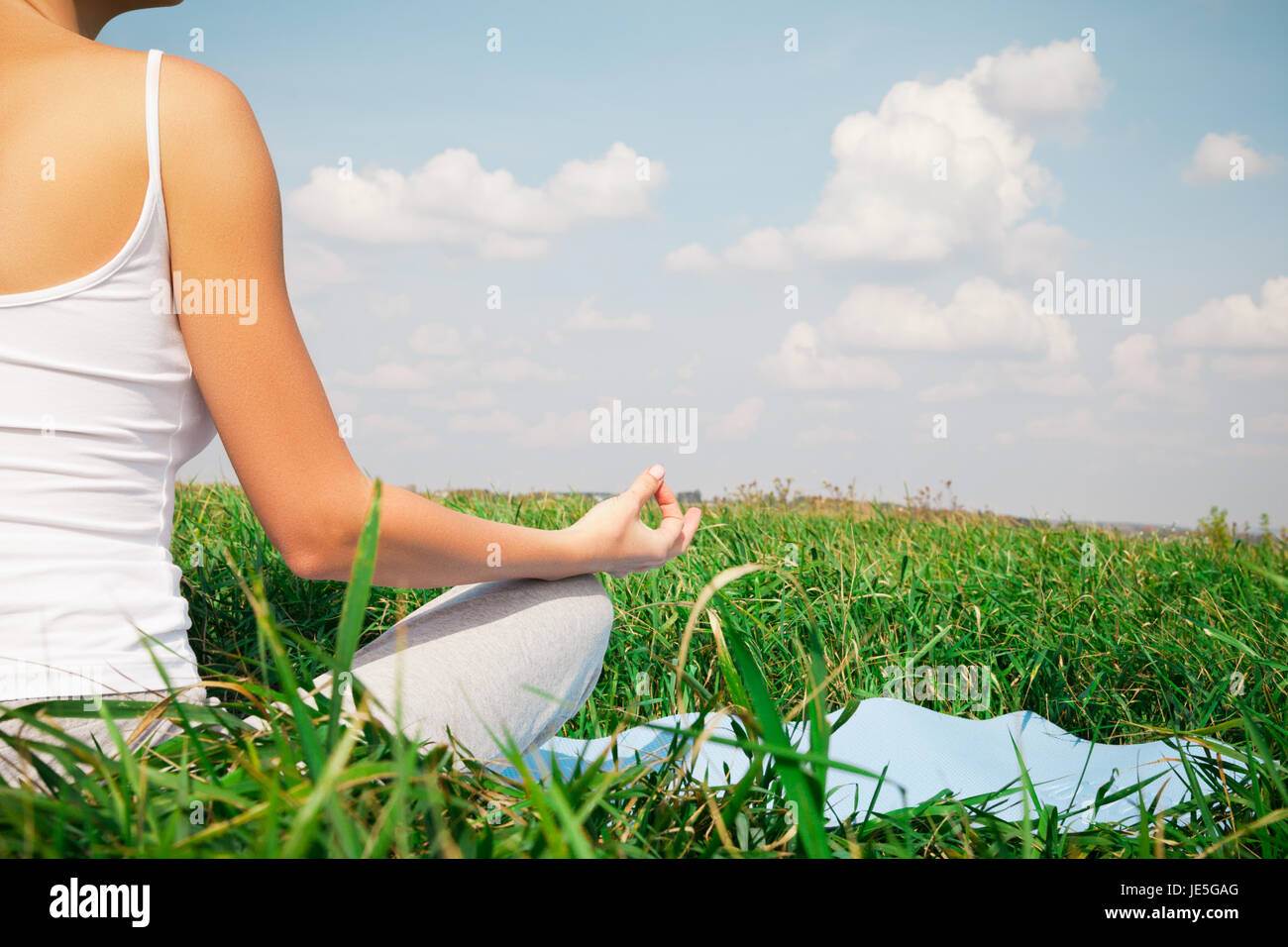 Young girl doing yoga lotus pose in the park Stock Photo - Alamy