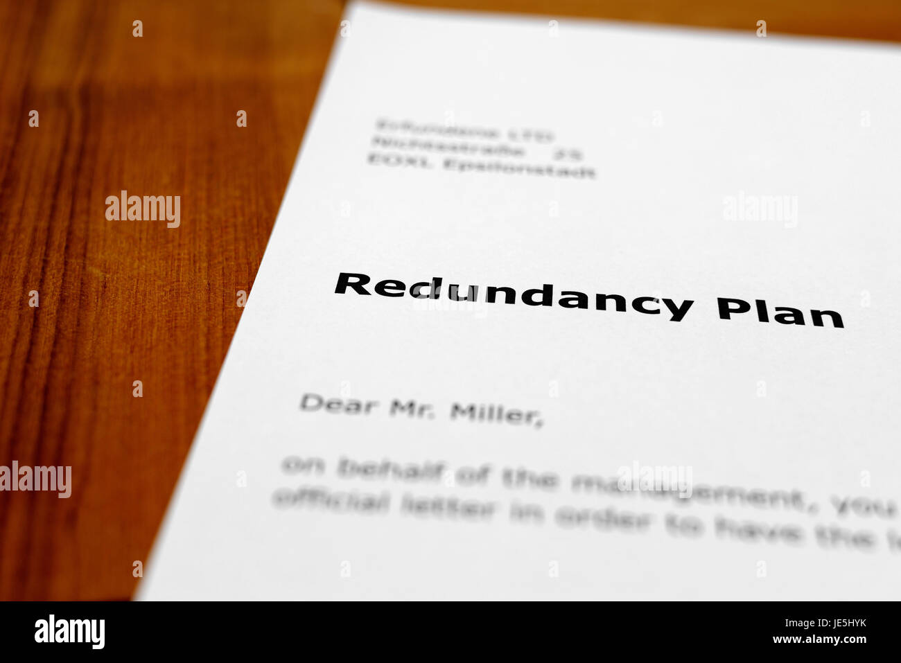 A letter on a wooden table - redundancy plan Stock Photo